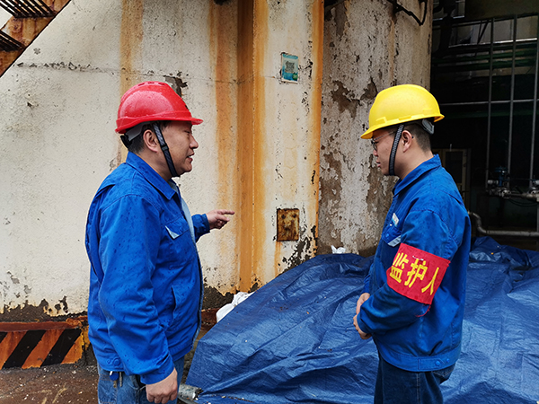 3月31日上午，在一期鍋爐舊脫硫塔底部清理現(xiàn)場(chǎng)，安全員焦路秦對(duì)監(jiān)護(hù)人岳維哲的提問(wèn)。.jpg