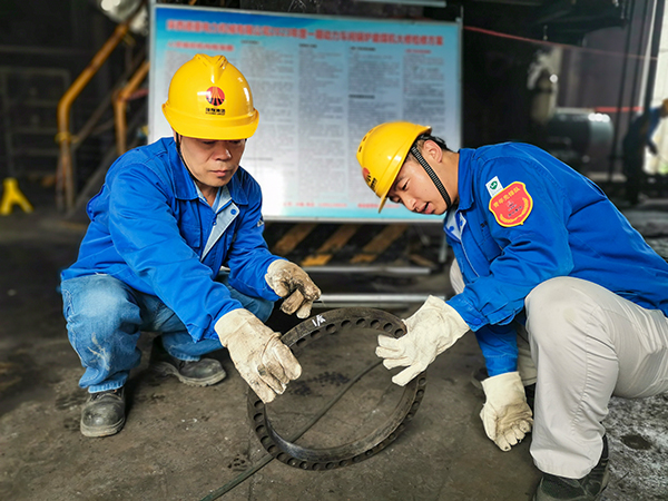 圖三：12日下午14時(shí)，在一期磨煤機(jī)廠房，陜西省技術(shù)能手姬霄給青工張跟潮講解磨煤機(jī)搖臂曲拐內(nèi)環(huán)及動(dòng)作原理。.jpg